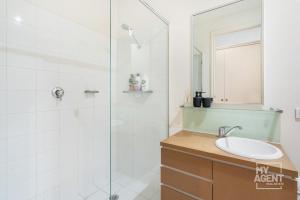 y baño con ducha y lavamanos. en Melbourne Bourke Street Bliss, en Melbourne