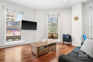 sala de estar con TV y sofá en Melbourne Bourke Street Bliss, en Melbourne