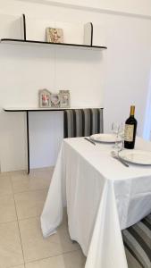 un tavolo bianco con una bottiglia di vino sopra di Vida Rose a Buenos Aires