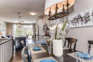 uma cozinha e sala de jantar com uma mesa com um vaso de flores em Riverside Villa em Kitchener