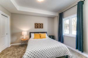 a bedroom with a bed with yellow pillows and a window at Riverside Villa in Kitchener