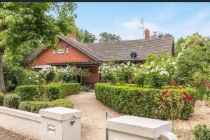 una casa con un jardín con flores y arbustos en • Parkside • Spacious central family retreat en Alfredton