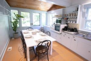 una cocina con mesa blanca y sillas. en • Parkside • Spacious central family retreat en Alfredton