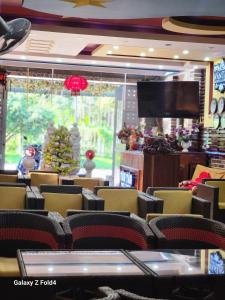 sala de estar con sillas y TV de pantalla plana en Vân Tân, en Kon Von Kla