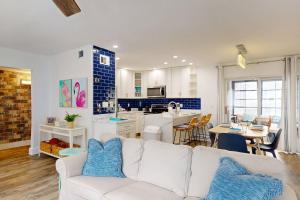 a living room with a white couch and a kitchen at 247-B - Madeira Beach Yacht Club in St. Pete Beach