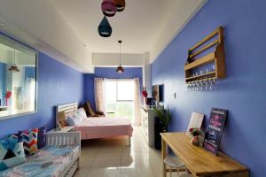 a bedroom with a bed and a blue wall at Sofias Place w/ Massagechair in Tagaytay