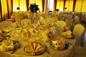 a table with yellow napkins and glasses on it at Hotel Du Parc in Atri