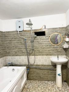 e bagno con doccia, lavandino e vasca. di Bảo Châu Garden a Buôn Dru Dak Mam