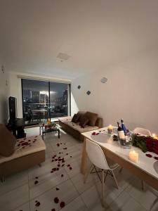 uma sala de estar com um sofá e uma mesa com flores no chão em Five Stars Suites - Paris - Quito em Quito