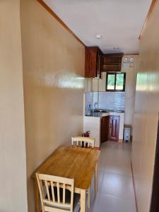 a small kitchen with a wooden table and chairs at Moalboal Cay in Moalboal +10 photos
