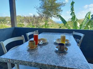 a blue table with two cups and plates of food at Feby's Homestay in Ekas