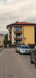 two cars parked in a parking lot in front of a building at STANZA ORO bagno con doccia idromassaggio in Udine