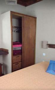 1 dormitorio con armario y cama. en Cabañas en Mar Azul en Balneario Mar Azul