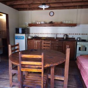 uma cozinha com uma mesa e cadeiras de madeira e uma cozinha com um fogão em Cabañas en Mar Azul em Mar Azul