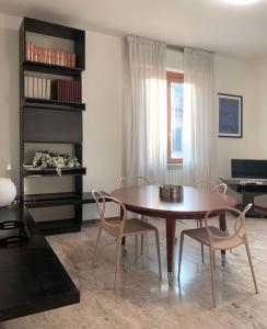 a living room with a wooden table and chairs at Mini Suite Cremona in Cremona