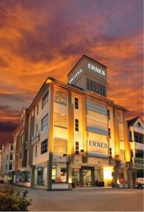 a large building with a sunset in the background at ERNES Hotel in Perai