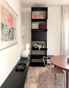 uma sala de jantar com uma mesa e uma prateleira preta em Mini Suite Cremona em Cremona