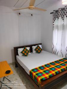 1 dormitorio con 1 cama con una manta colorida en Villa for Surf Weligama with Shisha, en Weligama