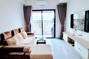 ein Wohnzimmer mit einem Sofa und einem großen Fenster in der Unterkunft Soho Reseident Dis 1 Ho Chi Minh City in Ho-Chi-Minh-Stadt