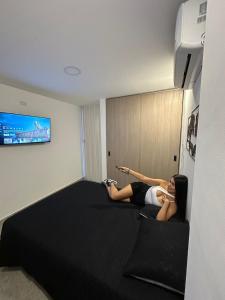 - deux femmes dormant sur un lit dans une chambre d'hôtel dans l'établissement Hermoso ApartaEstudio Centrico, à Cartago