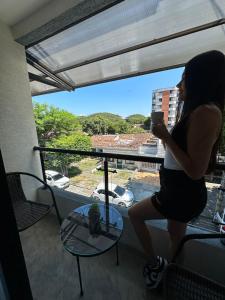 une femme prenant une photo d'une vue depuis un balcon dans l'établissement Hermoso ApartaEstudio Centrico, à Cartago