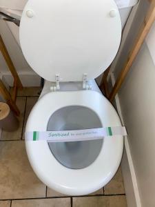 a white toilet with a sign taped to the seat at The Zen Home near Temple U & Drexel FREE STREET PARKING in Philadelphia