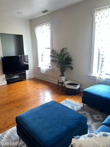 uma sala de estar com um sofá azul e uma televisão de ecrã plano em The Zen Home near Temple U & Drexel FREE STREET PARKING em Filadélfia