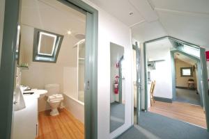 La salle de bains est pourvue de toilettes, d'un lavabo et d'un miroir. dans l'établissement 2 Bedroom Self Contained Apartment with Spa, à Ballarat