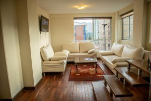 ラパスにあるConfortable y Amplio Apartamento Duplex en zona céntrica de Calacotoのリビングルーム(ソファ、椅子、窓付)