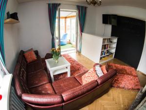 a living room with a brown leather couch and a table at Hostelino in Sopot