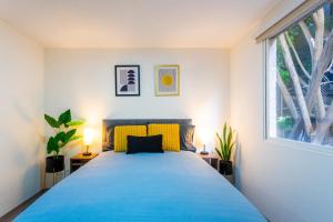 una camera con un letto blu e una finestra di Private bedroom in Roma Norte in Mexico City a Città del Messico