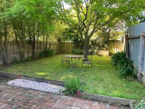 a backyard with a table and chairs and a tree at Macarthur House in Ballarat
