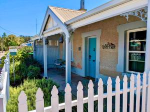 a white picket fence in front of a house at Inglenook Cottage in Moonta
