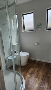 a bathroom with a glass shower and a toilet at Ashburton's Regency Motel in Ashburton