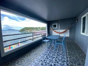 a balcony with a table and chairs and a view of the ocean at Anak Jay Ang in Puerto Galera