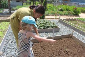 a woman and a little girl standing in a garden at Six Senses Con Dao - Turtle Island Paradise in Con Dao
