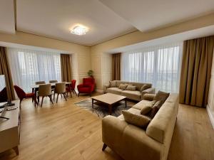 ein Wohnzimmer mit einem Sofa und einem Tisch in der Unterkunft Bishkek Park Residence in Bischkek