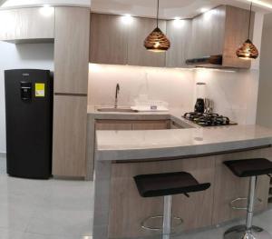 una cucina con lavandino, piano cottura e frigorifero di Encantador Apto Con Aire a Neiva