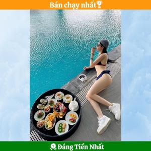 a woman in a bikini sitting next to a tray of food at Golden Star Hotel by THG in Da Nang