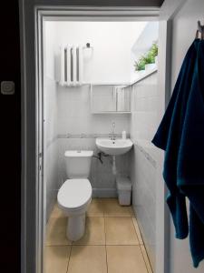 a white bathroom with a toilet and a sink at Hostelino in Sopot