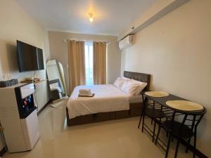 a small bedroom with a bed and a small table at Seaside Serenity w/ Sunrise @ Saekyung Village One in Lapu Lapu City