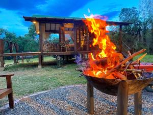 a fire pit with flames in front of a cabin at Hotel La Villa de Victoria Villa de Leyva in Sáchica