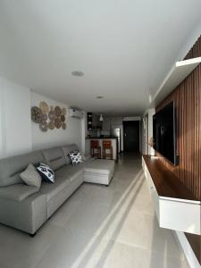 sala de estar con sofá y TV en Apartamento Vacacional frente al mar en General Villamil Playas, en Playas