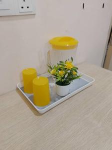 una bandeja con flores y tazas en una mesa en ABC Hostel, en Seri Kembangan