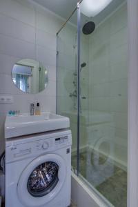 een wasmachine in een badkamer met een wastafel en een douche bij Asaapart Mega Studio 2 in Alma-Ata