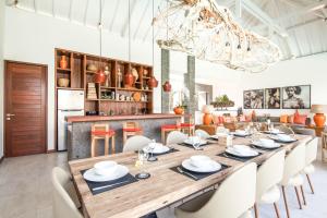 a dining room with a large wooden table and chairs at Dreamy 5br Haven, 200m To Berawa's Blissful Beach in Canggu