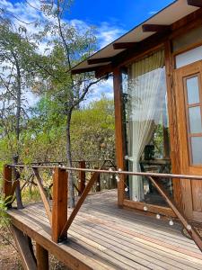 a wooden cabin with a glass door on a deck at Hotel La Villa de Victoria Villa de Leyva in Sáchica