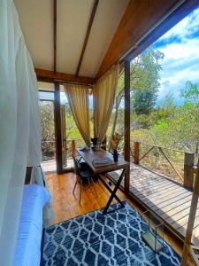 a bedroom with a bed and a table and a balcony at Hotel La Villa de Victoria Villa de Leyva in Sáchica