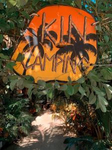 ホルボックス島にあるKin Hostal and Campingの庭の落書きが入ったオレンジ色の看板