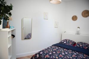 Un dormitorio con una cama y un espejo en la pared. en Sapio, en Angers